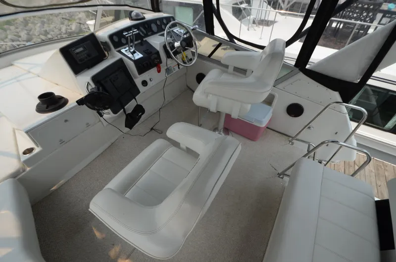 Slide: The Image of 1995 Carver 370 Voyager boat cockpit with white leather seats and control panel. - 10