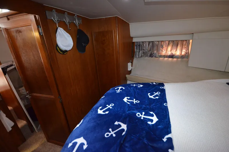 Slide: The Image of Cozy bedroom in a 1995 Carver 370 Voyager with nautical-themed bedding. - 13