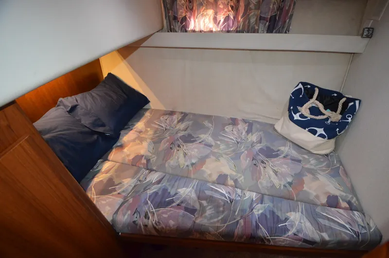 Slide: The Image of Cozy cabin bed in a 1995 Carver 370 Voyager yacht with floral bedding and nautical decor. - 14