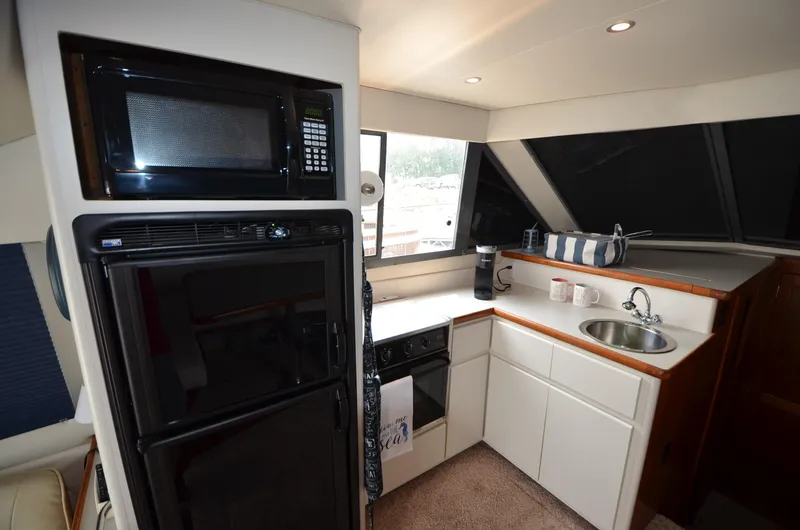 Slide: The Image of Compact kitchen area in a 1995 Carver 370 Voyager yacht with microwave, fridge, and sink. - 17