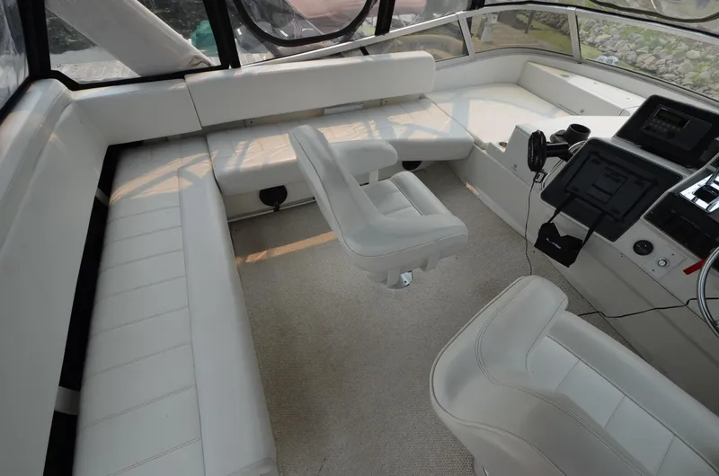 Slide: The Image of Interior of 1995 Carver 370 Voyager yacht with white seating and helm station. - 8