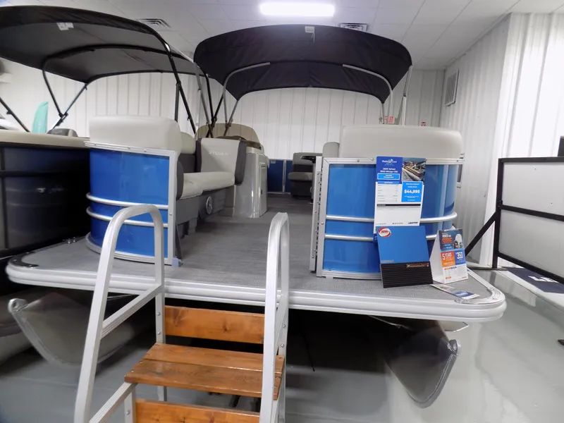 Slide: The Image of 2023 Sylvan 8522 Mirage Cruise pontoon boat displayed indoors with blue exterior. - 2