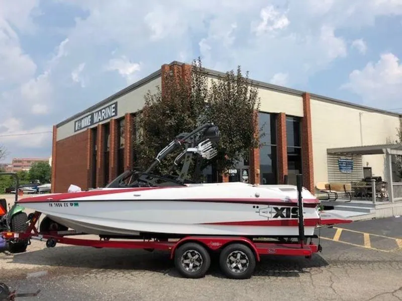 Slide: The Image of 2012 Axis Wake Research A-22 boat on trailer outside marine building. - 0