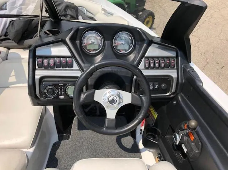 Slide: The Image of 2012 Axis Wake Research A-22 boat dashboard with steering wheel and control panel. - 16