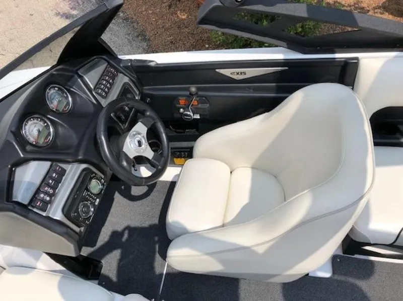 Slide: The Image of 2012 Axis Wake Research A-22 boat interior with steering wheel and white captain's chair. - 26