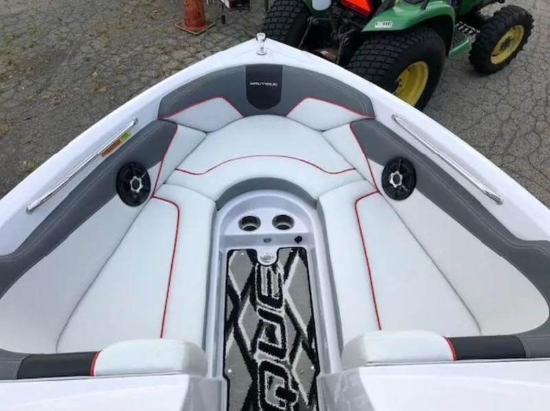 Slide: The Image of 2013 Nautique Super Air Nautique 230 boat interior with white and gray seating, red accents. - 11