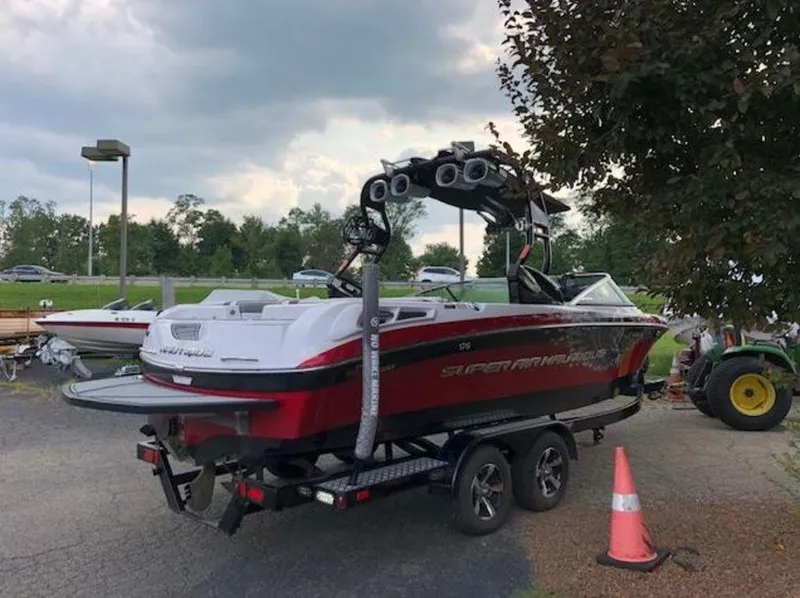 Slide: The Image of 2013 Nautique Super Air Nautique 230 boat on trailer, parked outdoors. - 28