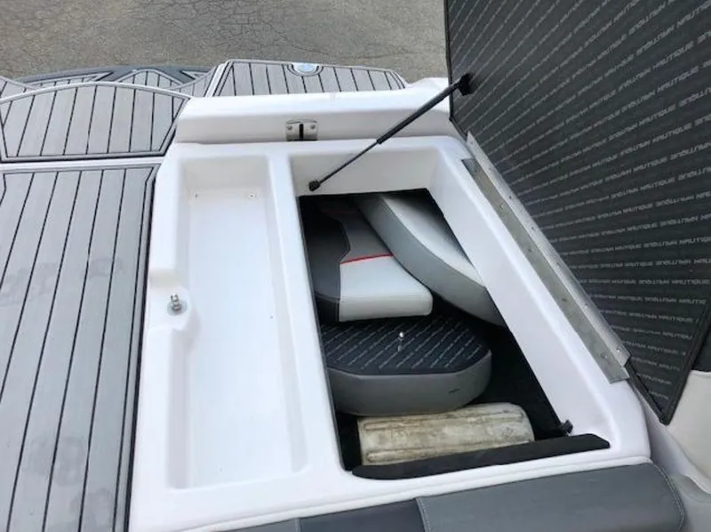 Slide: The Image of Open storage compartment on 2013 Nautique Super Air Nautique 230 boat, showing interior space and cushions. - 37