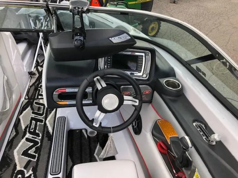 Slide: The Image of 2013 Nautique Super Air Nautique 230 boat dashboard with steering wheel and control panel. - 38