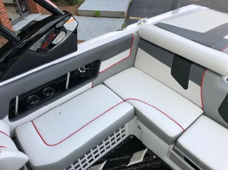 Slide: The Image of 2013 Nautique Super Air Nautique 230 interior with white and gray seating, red accents. - 39