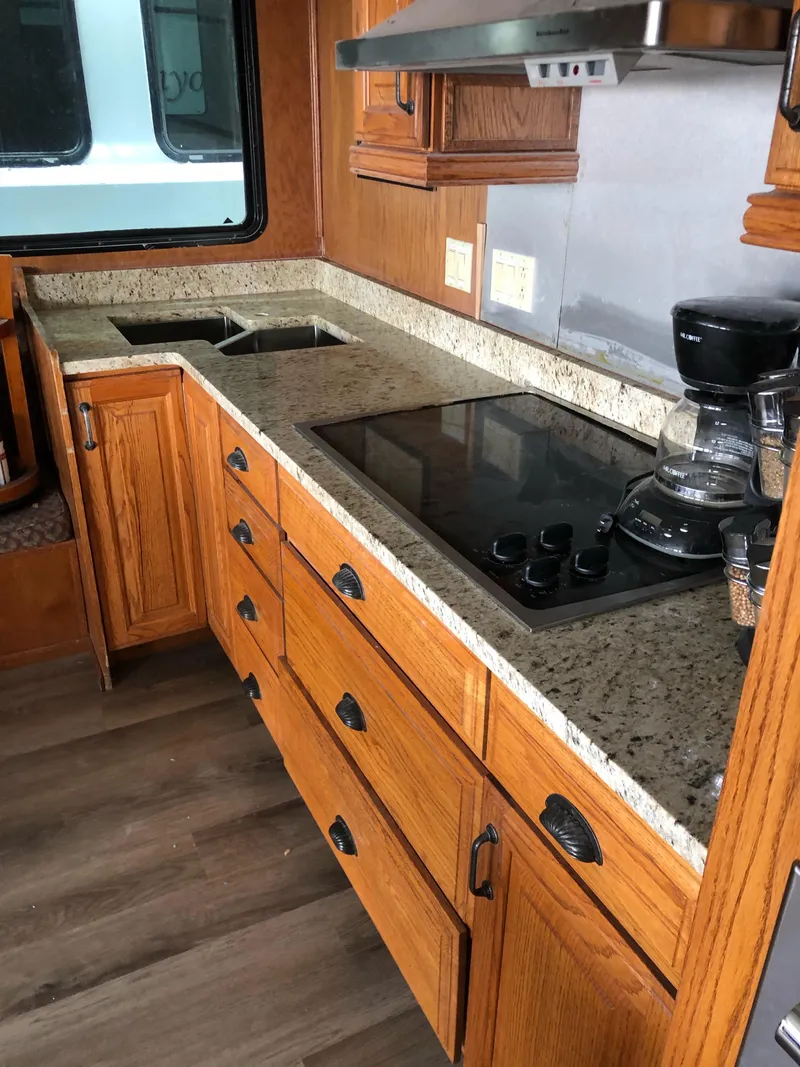 Slide: The Image of 2004 Sumerset Wind Walker kitchen with granite countertops and wooden cabinets. - 10