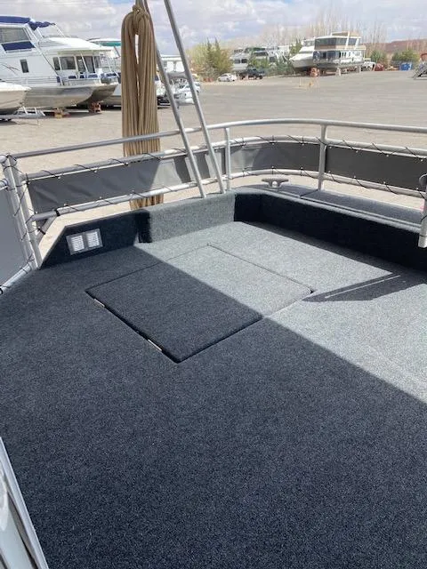 Slide: The Image of 2004 Sumerset Wind Walker boat deck with carpeted flooring in a marina setting. - 26