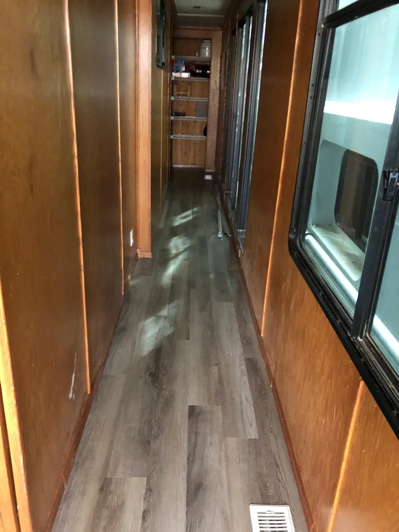 Slide: The Image of Narrow hallway inside 2004 Sumerset Wind Walker houseboat with wooden walls and flooring. - 6