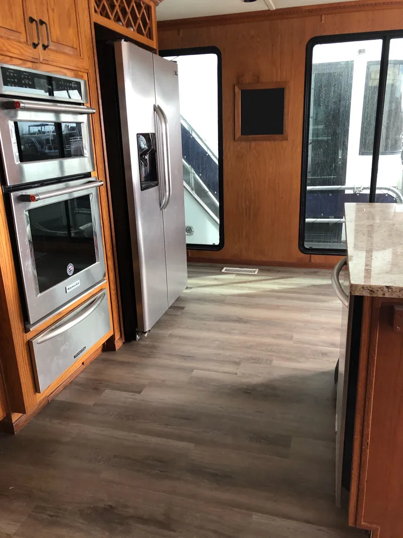 Slide: The Image of 2004 Sumerset Wind Walker kitchen with stainless steel appliances and wood flooring. - 7