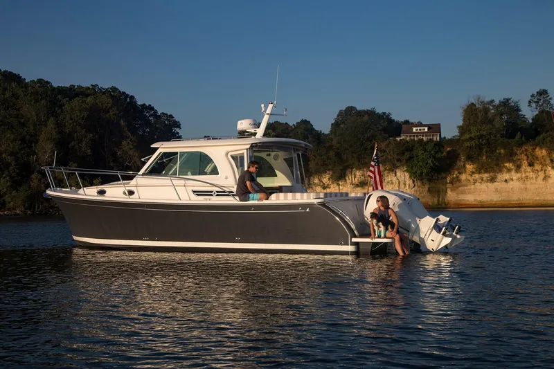 Slide: The Image of 2024 Back Cove 34O boat on calm water with people onboard. - 11