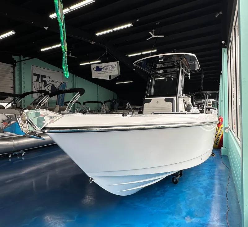 Slide: The Image of 2025 Edgewater 230CC Center Console boat displayed in a showroom. - 1