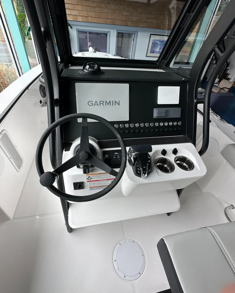 Slide: The Image of 2025 Edgewater 230CC Center Console with Garmin navigation system and sleek interior design. - 14