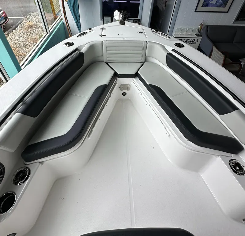 Slide: The Image of 2025 Edgewater 230CC Center Console boat interior with cushioned seating and cup holders. - 20