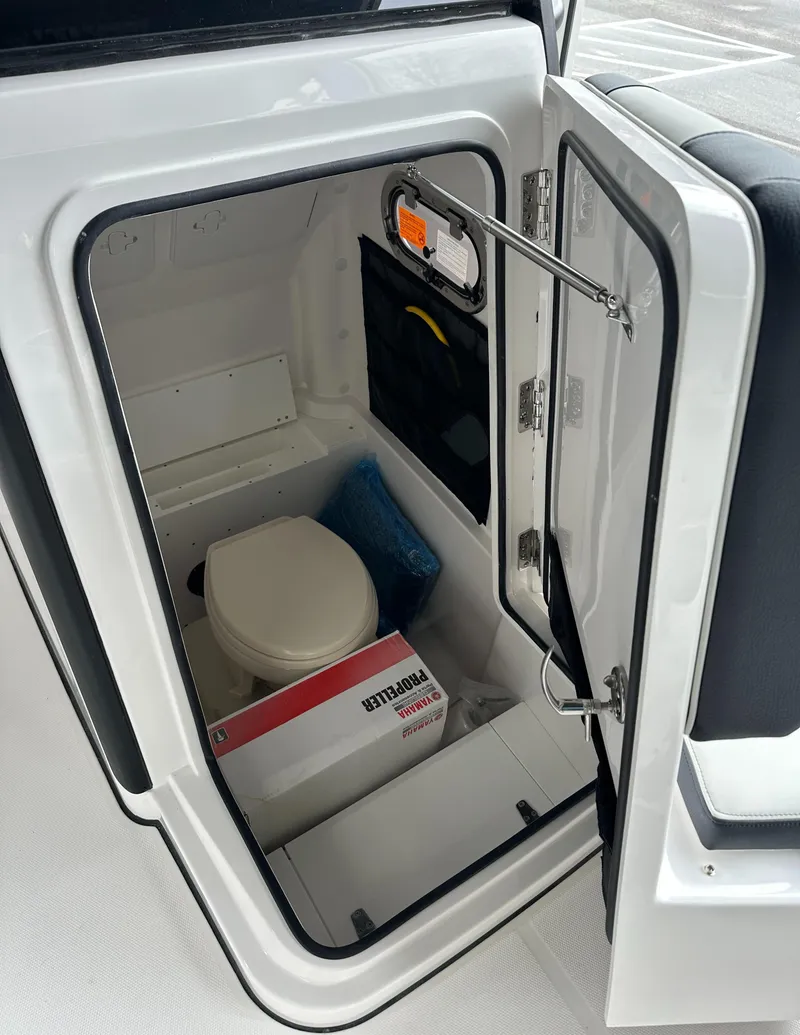 Slide: The Image of 2025 Edgewater 230CC Center Console boat interior with compact marine toilet. - 30