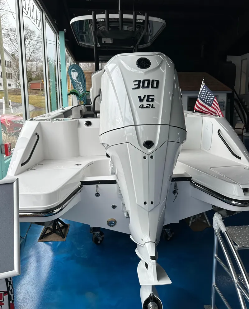 Slide: The Image of 2025 Edgewater 230CC Center Console boat with 300 V6 engine, displayed indoors. - 6