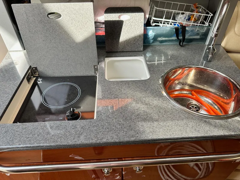 Slide: The Image of 2012 Formula 350 Sun Sport boat kitchenette with stove, sink, and countertop. - 28
