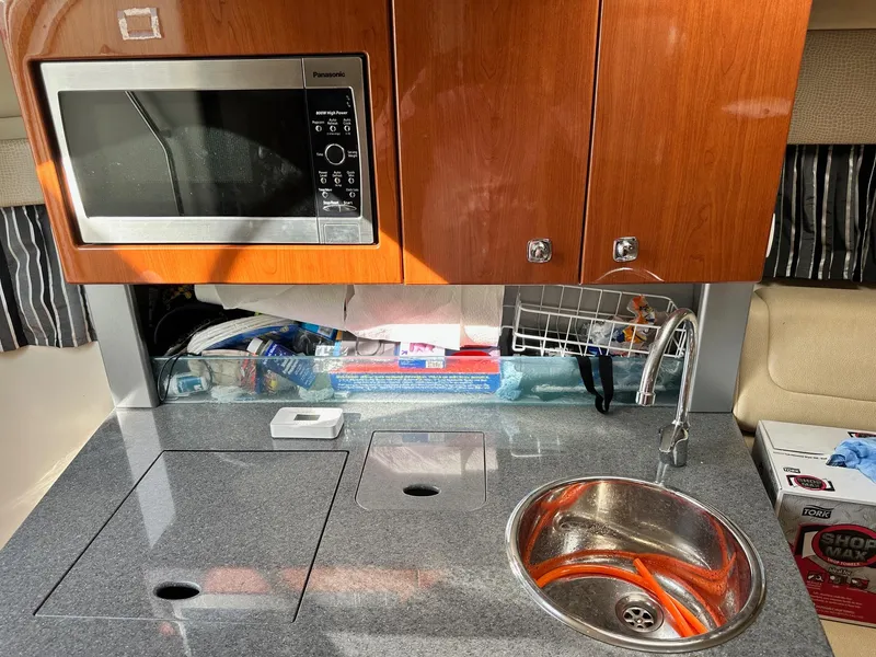 Slide: The Image of Compact kitchen area in a 2012 Formula 350 Sun Sport boat with microwave and sink. - 29