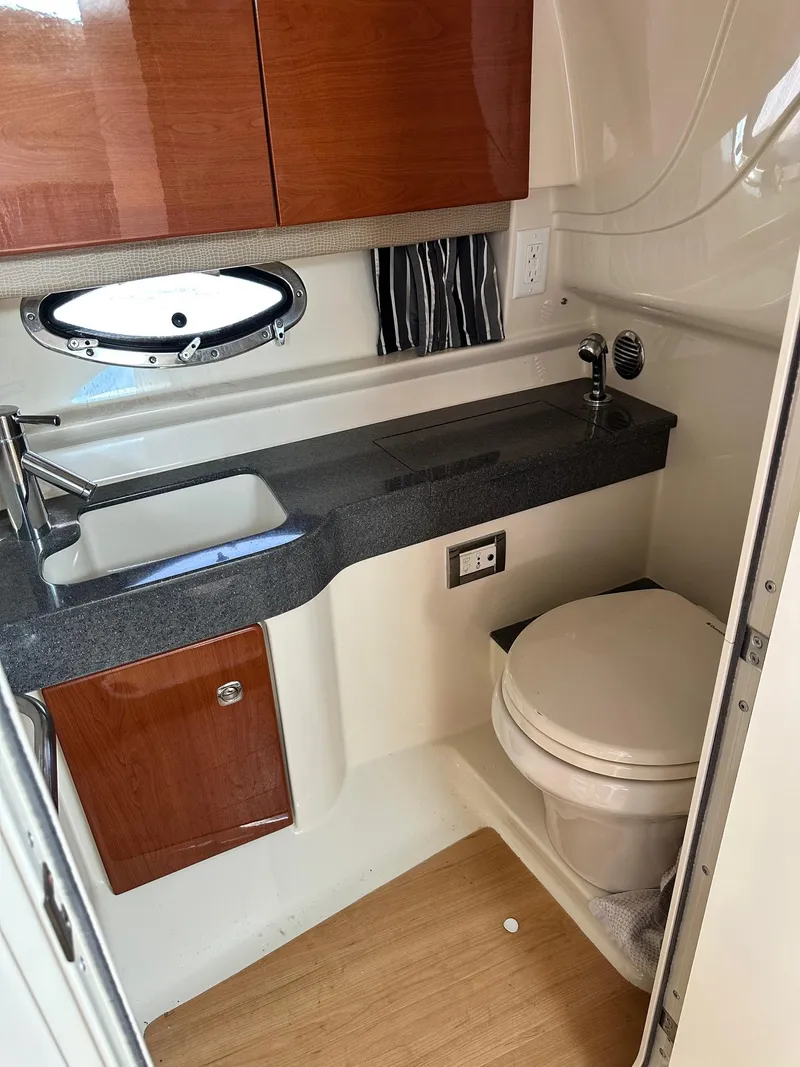 Slide: The Image of 2012 Formula 350 Sun Sport boat bathroom with sink, toilet, and wooden cabinetry. - 37
