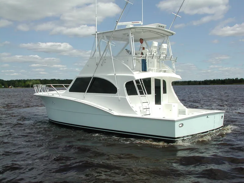 Slide: The Image of 2024 44' Jersey Cape Custom yacht cruising on a lake under a partly cloudy sky. - 2