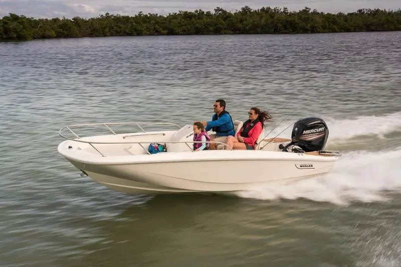 Slide: The Image of 2023 Boston Whaler 160 Super Sport boat cruising on a lake with three passengers. - 5
