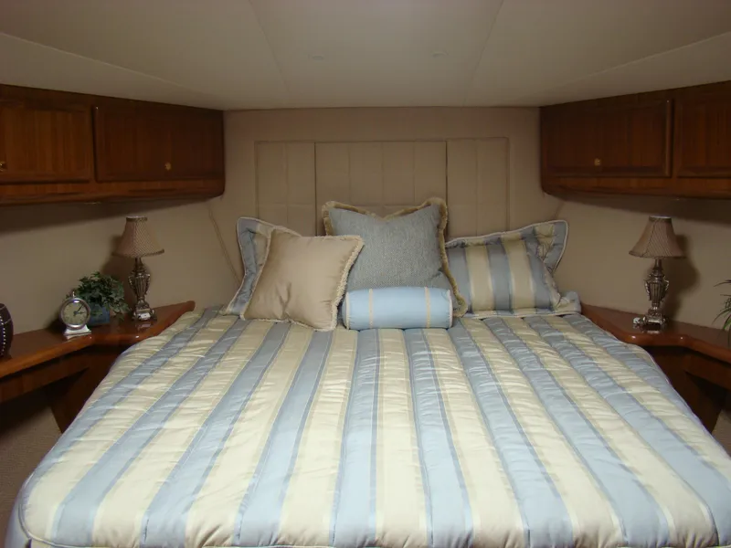 Slide: The Image of Luxurious bedroom interior of 2024 Jersey Cape 48 Custom yacht with striped bedding. - 9