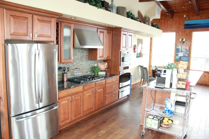 Slide: The Image of Modern kitchen with stainless steel appliances, wooden cabinets, and a mobile kitchen cart. - 10