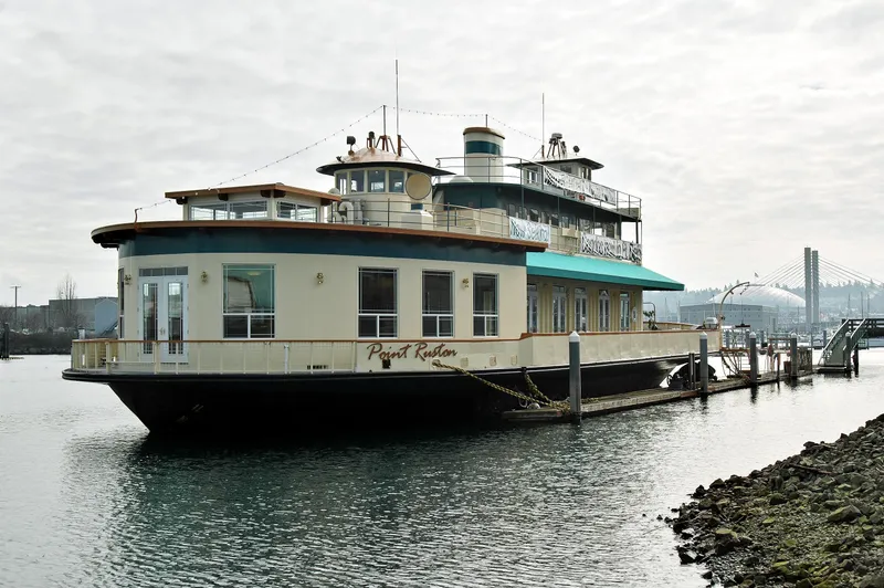 Slide: The Image of 1936 Custom Ferry docked on a calm waterway with a bridge in the background. - 3
