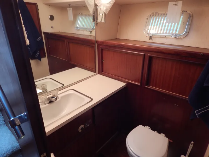 Slide: The Image of 1972 Hatteras 38 Convertible yacht bathroom with sink, mirror, and wooden cabinetry. - 17