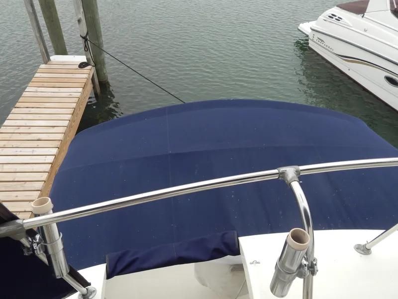 Slide: The Image of 1972 Hatteras 38 Convertible boat with blue canopy docked at marina. - 7