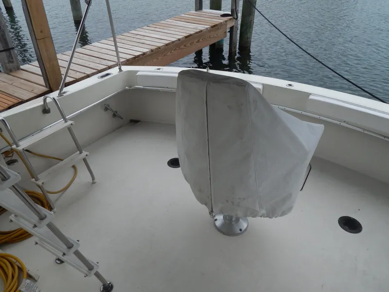 Slide: The Image of 1972 Hatteras 38 Convertible boat deck with covered chair and dock view. - 9