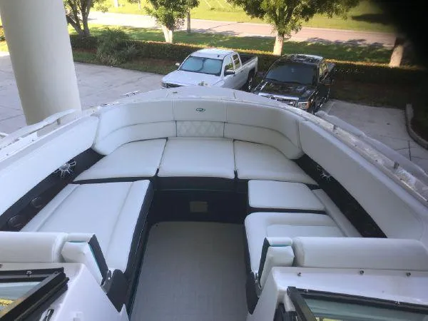 Slide: The Image of 2022 Regal 29 OBX boat with spacious white seating area, parked outdoors. - 8