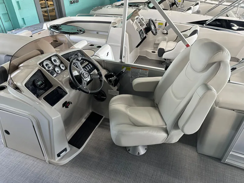 Slide: The Image of 2025 Sylvan Mirage 8522 CLZ DH boat interior with captain's chair and control panel. - 8
