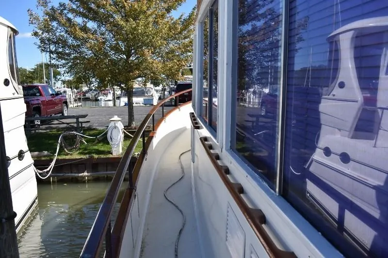 Slide: The Image of 1985 Grand Banks 49 Motoryacht docked with tree in background. - 22