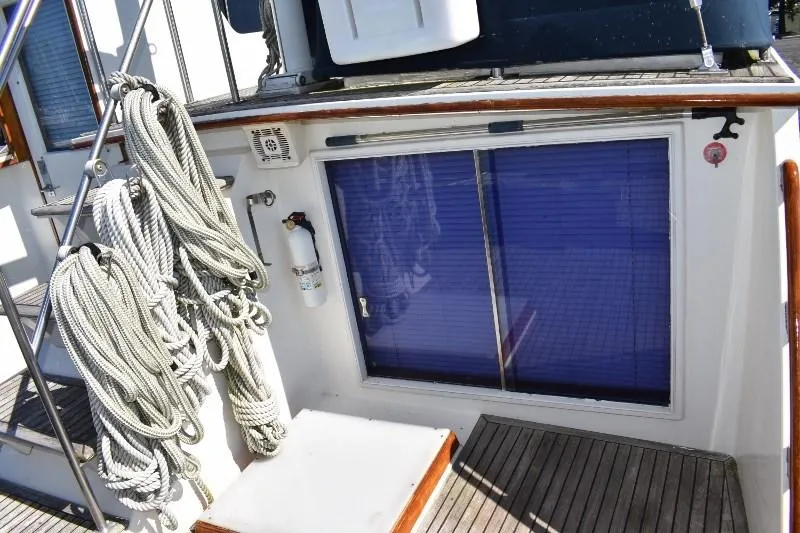Slide: The Image of 1985 Grand Banks 49 Motoryacht deck area with ropes and blue doors. - 30
