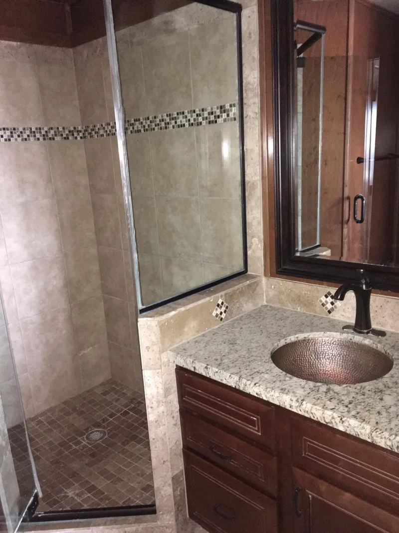 Slide: The Image of Luxurious bathroom with granite sink and tiled shower, Bravada 2012. - 13