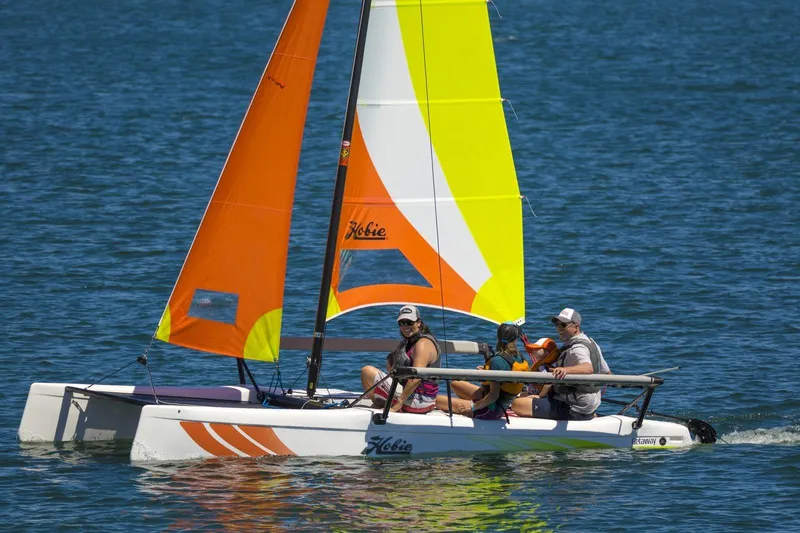 The Image of 2023 Hobie Cat Getaway sailboat with colorful sails on the water. - 0
