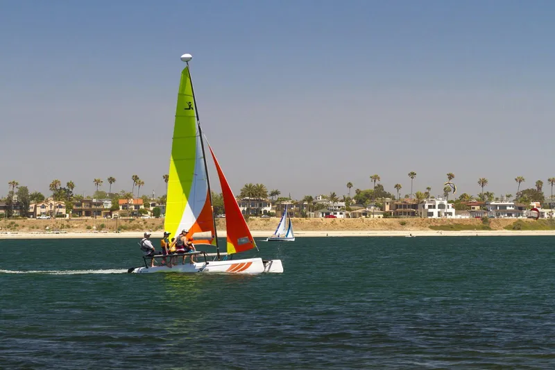 Slide: The Image of 2023 Hobie Cat Getaway sailing on a sunny day near the coast. - 2