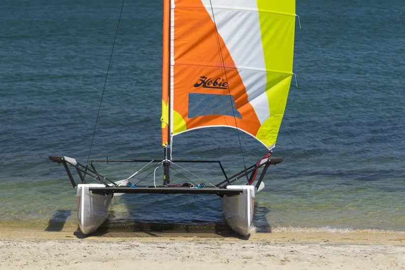 Slide: The Image of 2023 Hobie Cat Getaway sailboat on sandy beach by the water. - 3