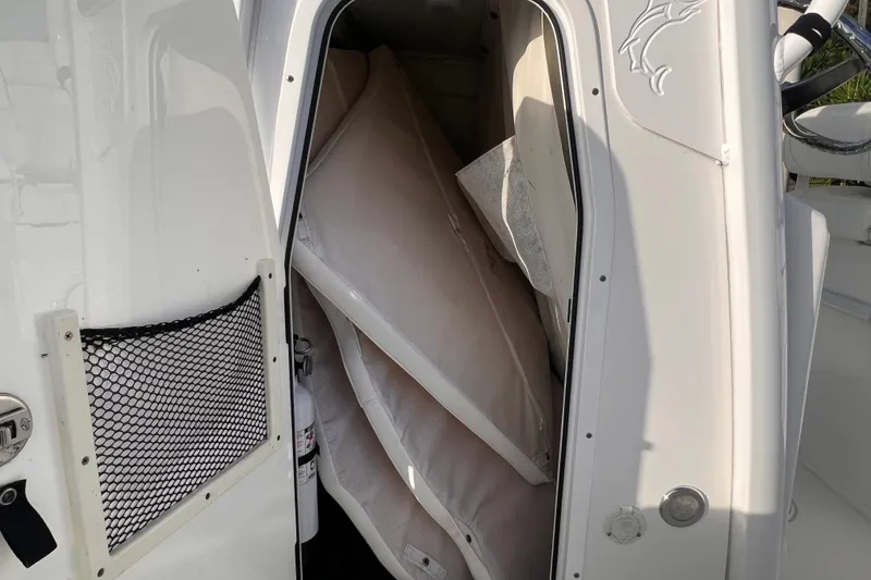 Slide: The Image of 2019 Sea Hunt BX 25 FS boat storage compartment with cushions and fire extinguisher. - 22
