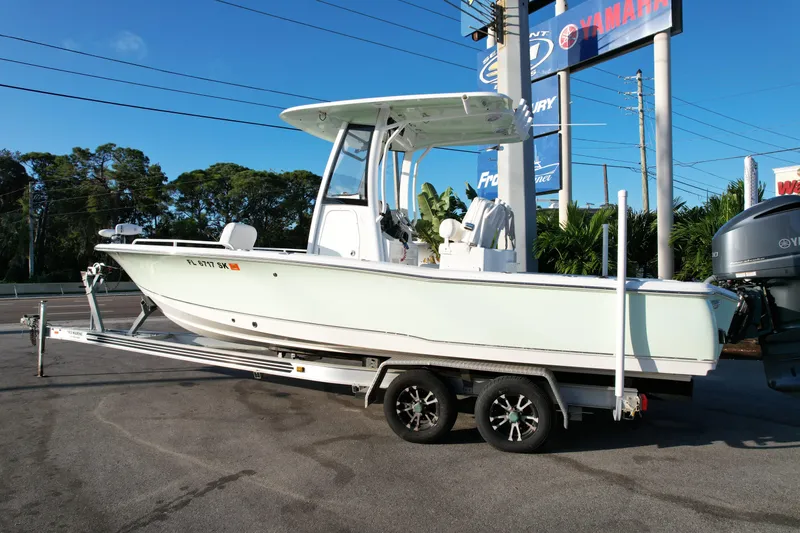 Slide: The Image of 2019 Sea Hunt BX 25 FS boat on trailer, parked outdoors near dealership signs. - 24