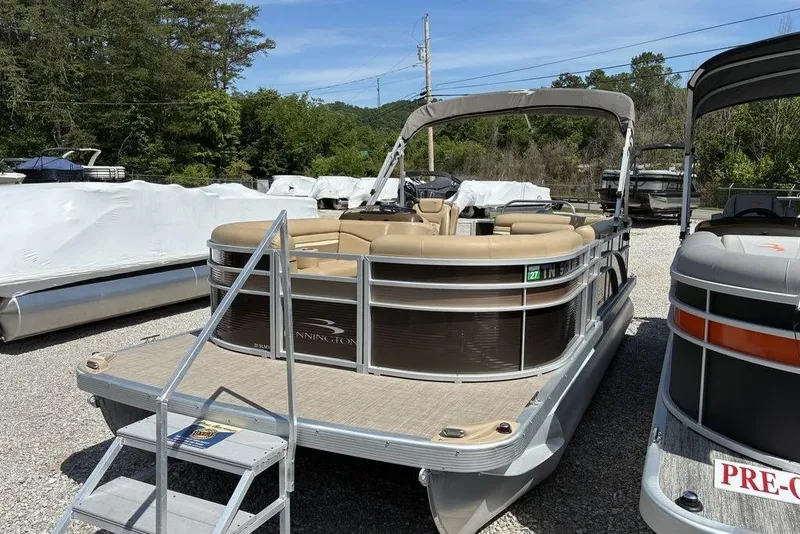 The Image of 2017 Bennington 20SLMX pontoon boat with beige seating, parked outdoors. - 1