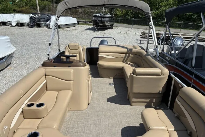 Slide: The Image of 2017 Bennington 20SLMX pontoon boat with beige seating and canopy in a marina. - 3