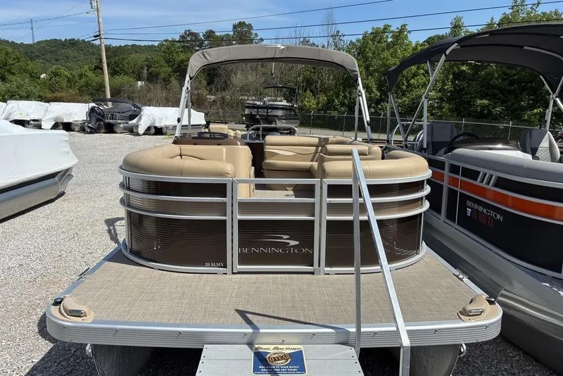 Slide: The Image of 2017 Bennington 20SLMX pontoon boat with beige seating, parked outdoors. - 4