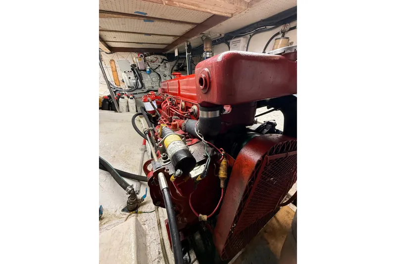 Slide: The Image of Engine room of a 1982 Krogen 42 boat with red machinery components. - 14