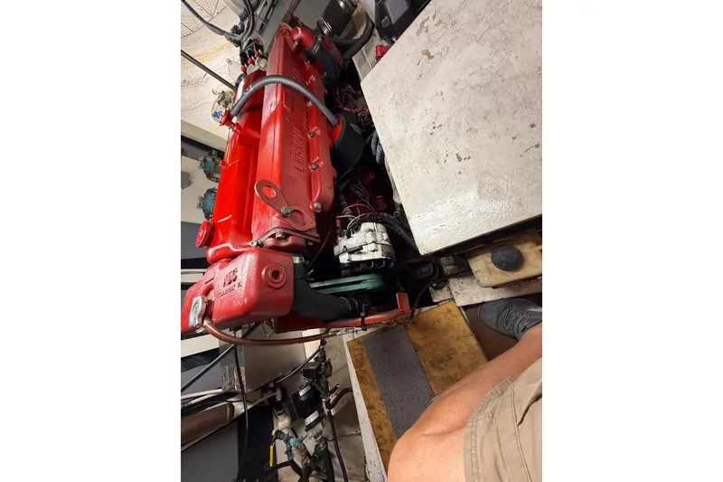 Slide: The Image of Engine room of 1982 Krogen 42 boat with red engine components. - 18